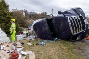 overturned semi-truck with road worker