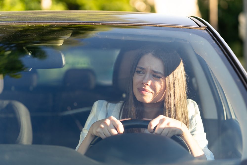 A confused driver, wondering if it is illegal to drive without insurance.