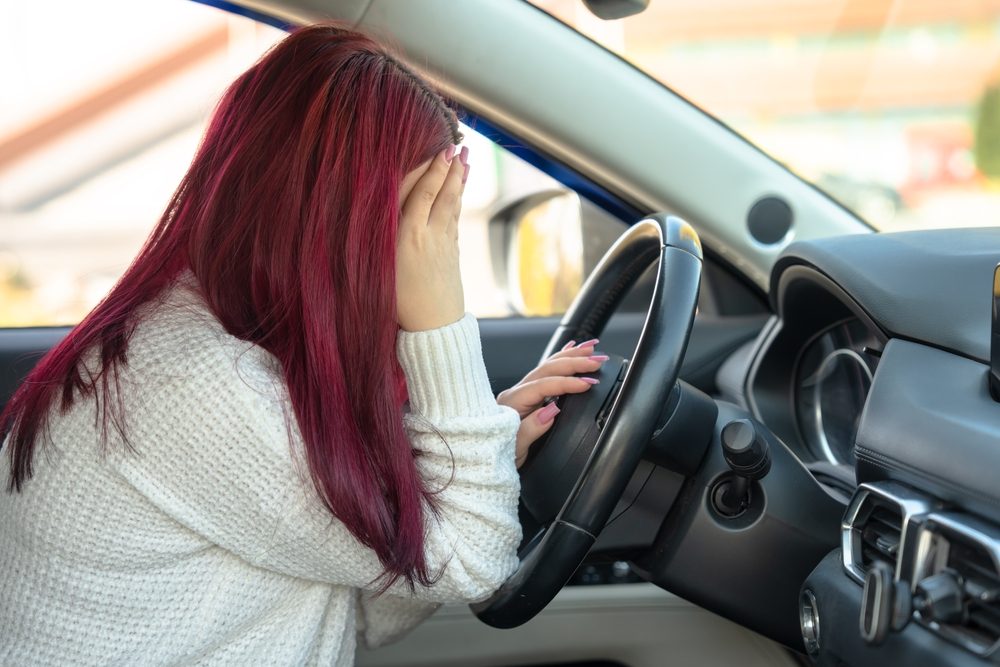 Person behind the wheel of a car who may be dealing with some of the symptoms of trauma after a car accident